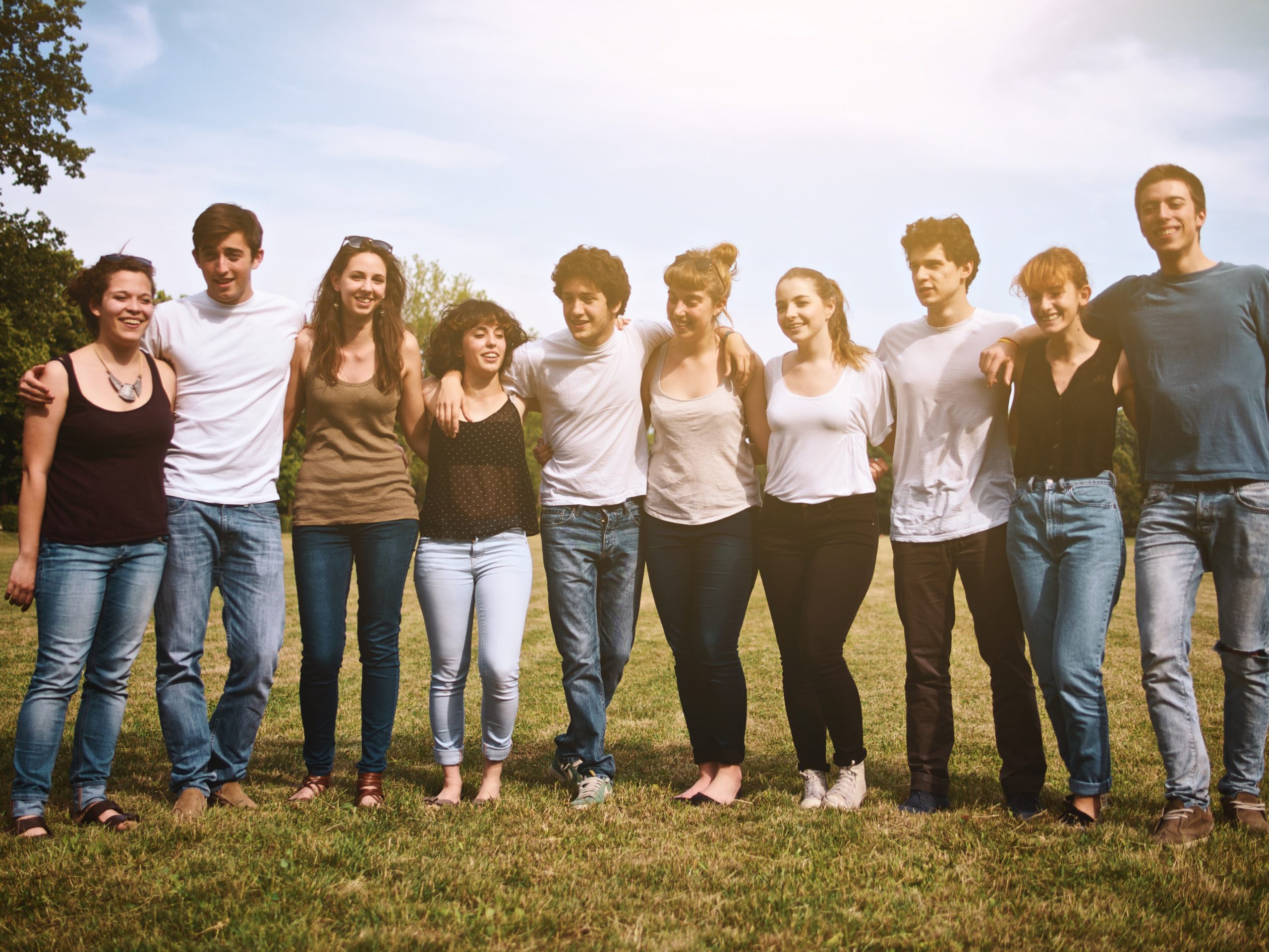 large group of friends enjoying a summer day at the park, back to school